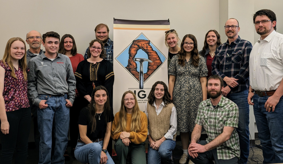 Twelve of the fourteen recipients of the 2024 UGA-UGF Utah Field Camp Scholarship, whose names are listed below, attended the April UGA Luncheon in person and were celebrated by everyone in attendance. Awards were presented by UGA President Eugene Szymanski (standing; plaid shirt on right), UGA Scholarship Chair Zach Anderson (kneeling; on right), and UGF President Paul Anderson (glasses; on left). The awardees represent the geology programs of seven different Utah universities that are sending students to field camp this year. (Not pictured:  Parker Tenney, Southern Utah University, and Chloe FitzGerald, Southern Utah University)